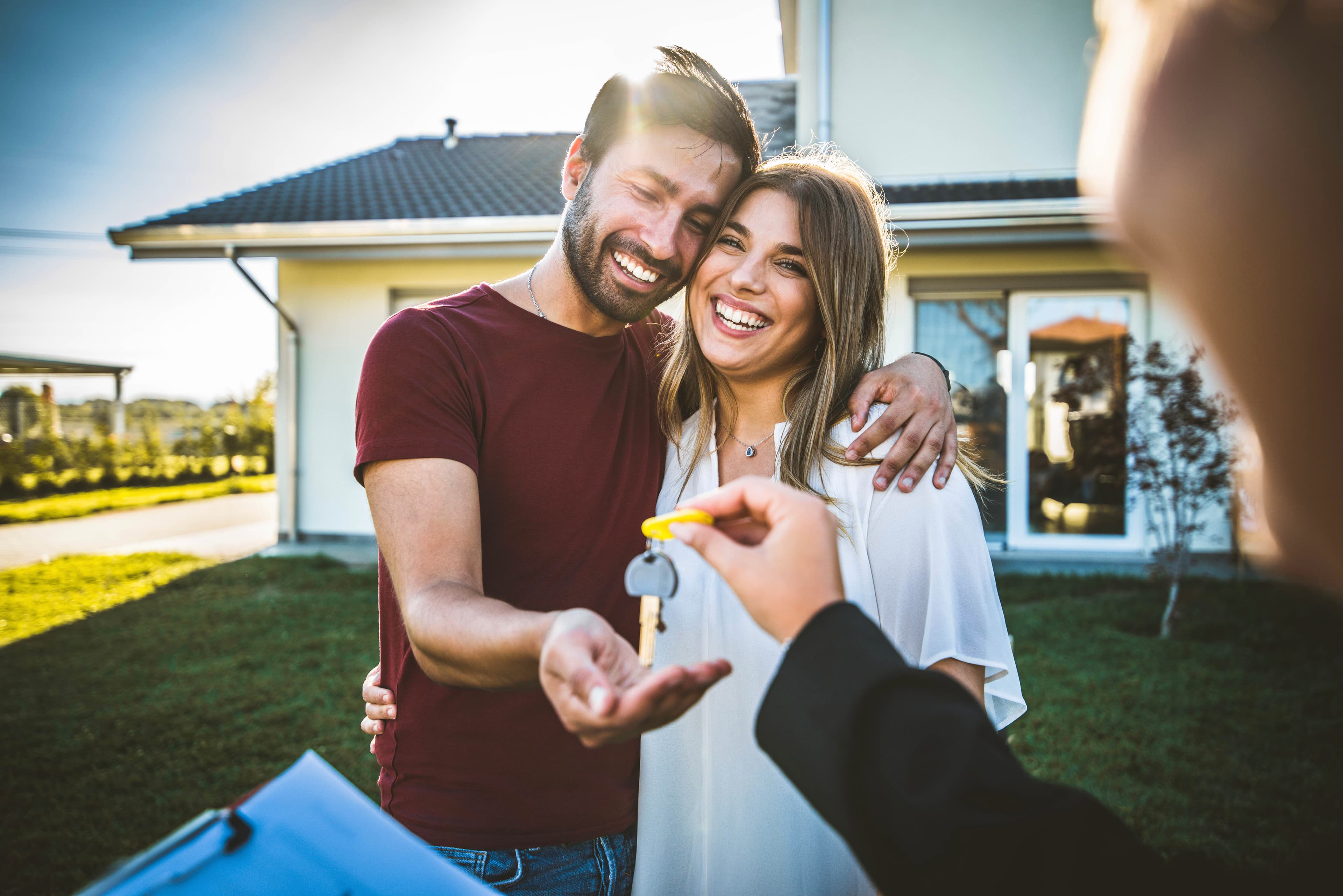 New homeowners standing in front of their home