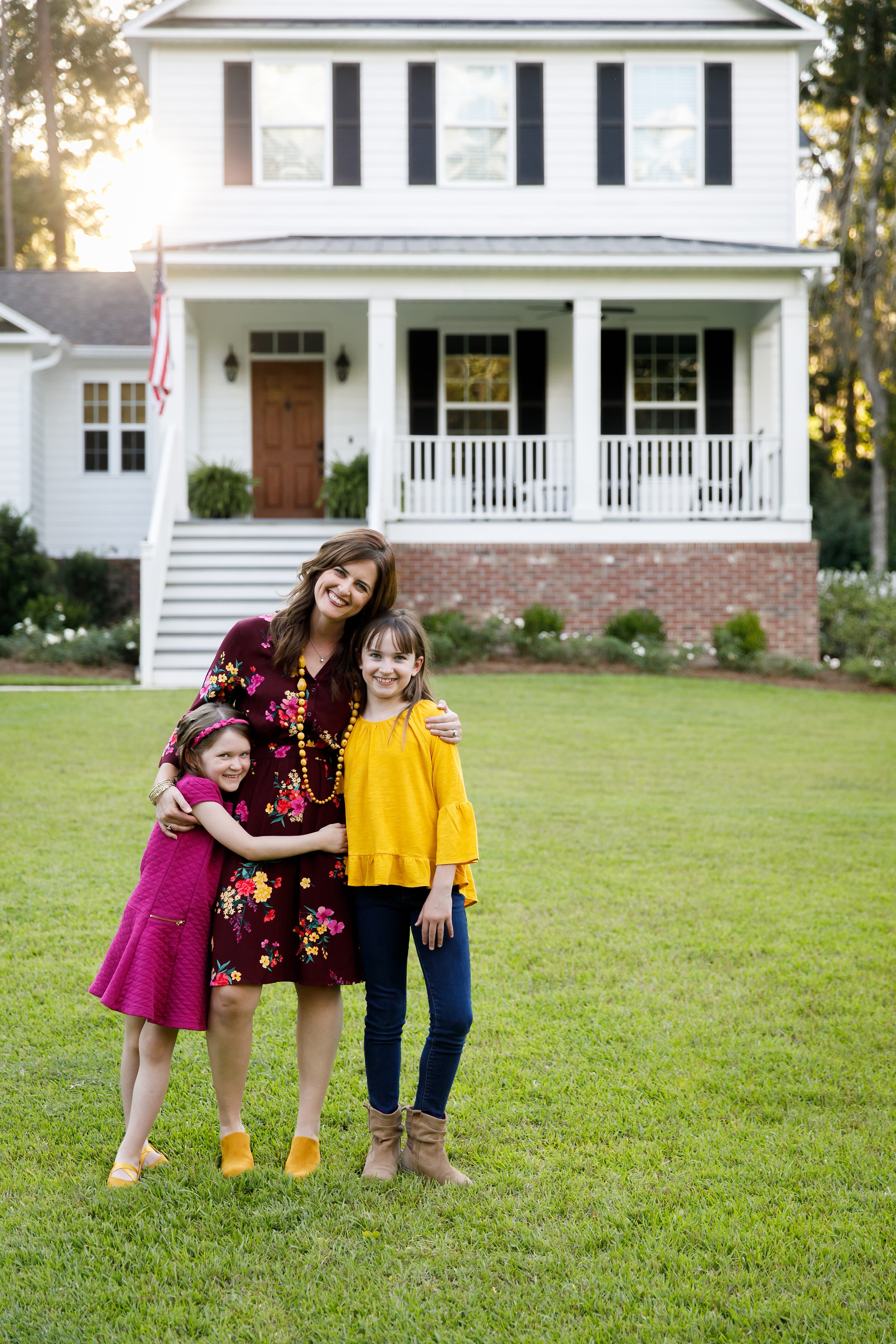 Homebuyer holding keys in front of a new home